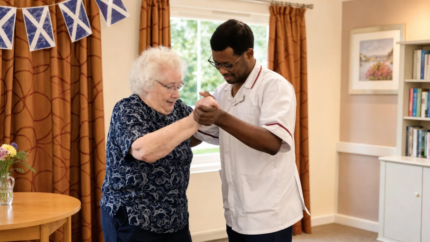 A colleague dancing hand in hand with a resident at St Olaf Care Home in Nairn