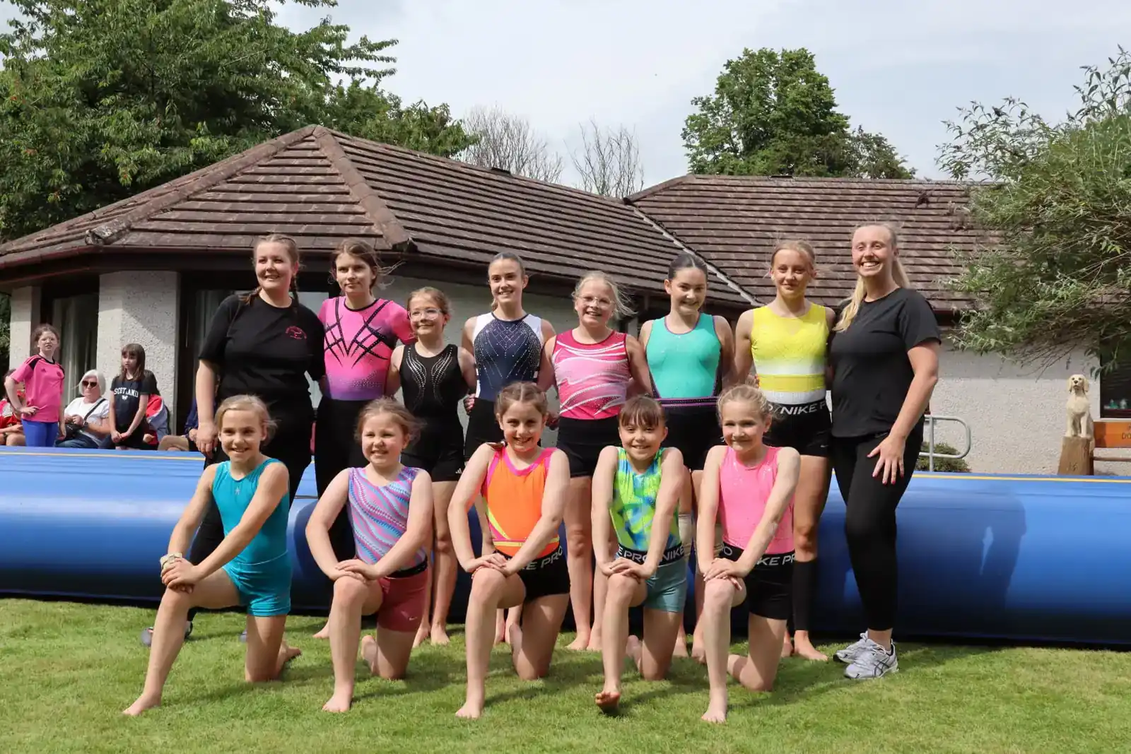 Young gymnasts from Fyrish Gymnastics in Alness kneeling in a group outside Redwoods Care Home after their display for residents