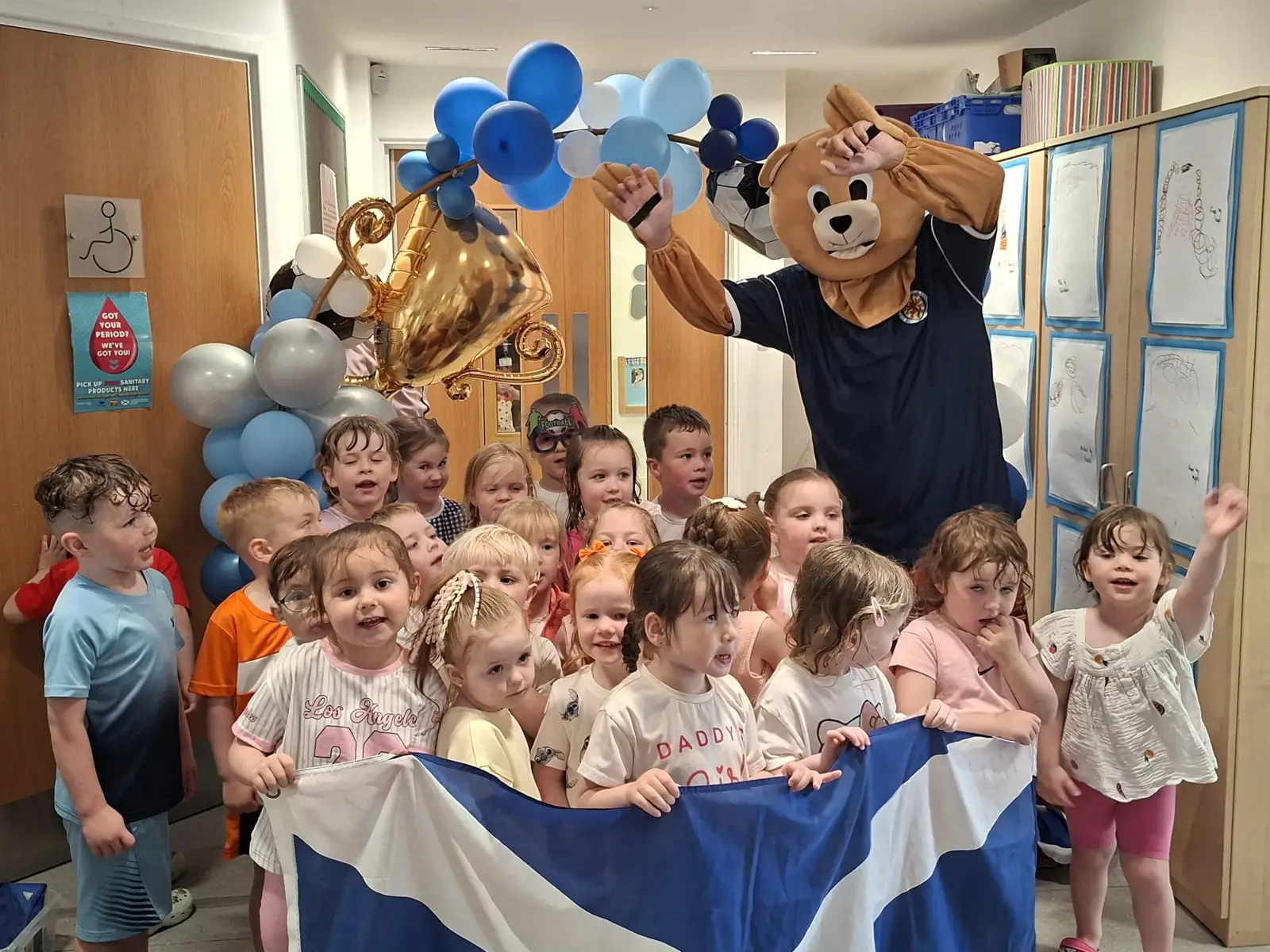 Children from Glenbrae Nursery holding a Saltire flag with Roary the mascot and balloons during the Big Kick Off at Kincaid House Care Home