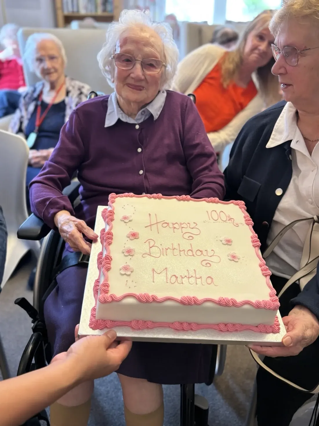 Martha holding a Happy Birthday Martha cake marking her 100th birthday at Kynnaird House Care Home