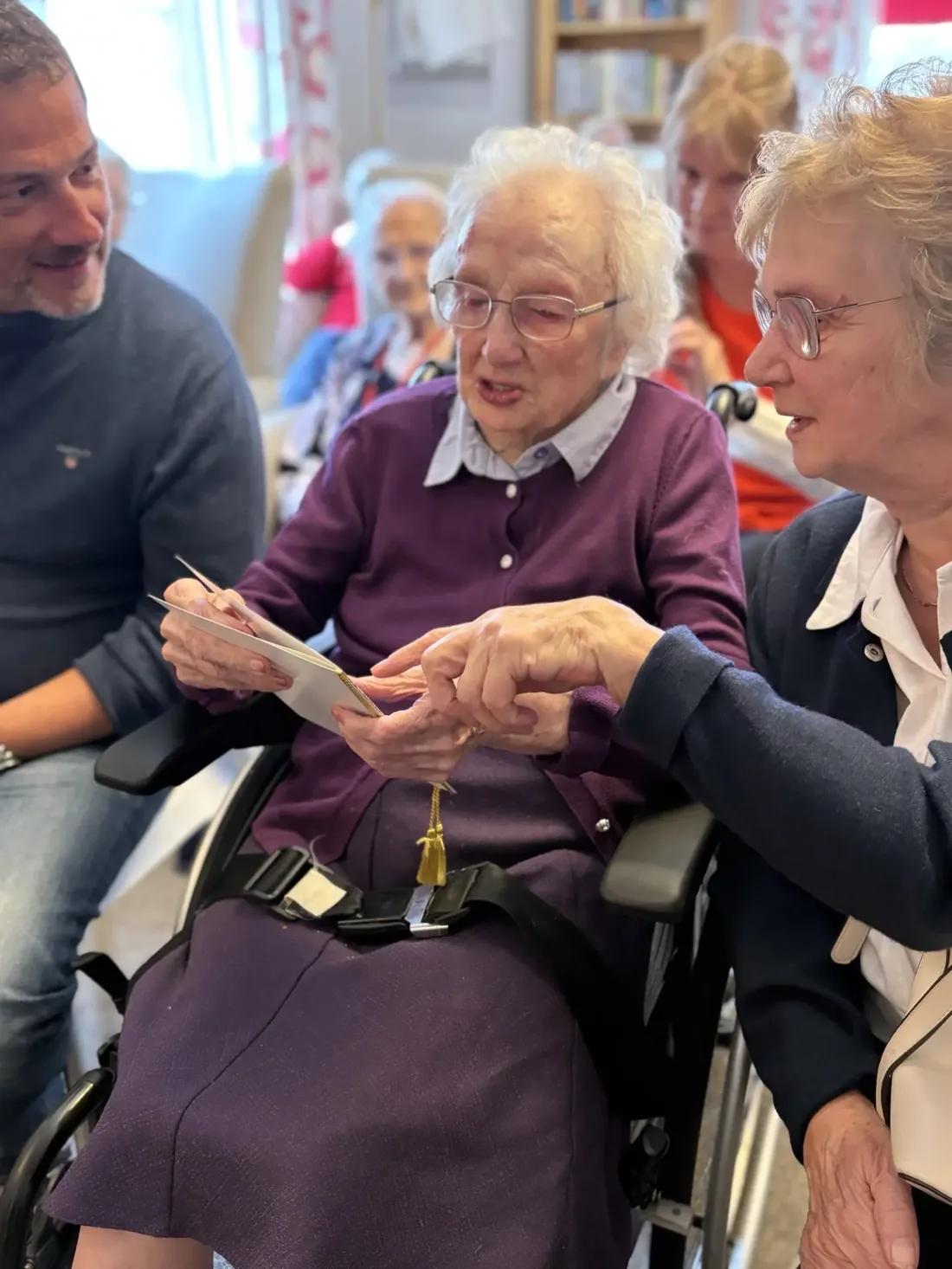 Martha reading her birthday cards with family members at Kynnaird House Care Home