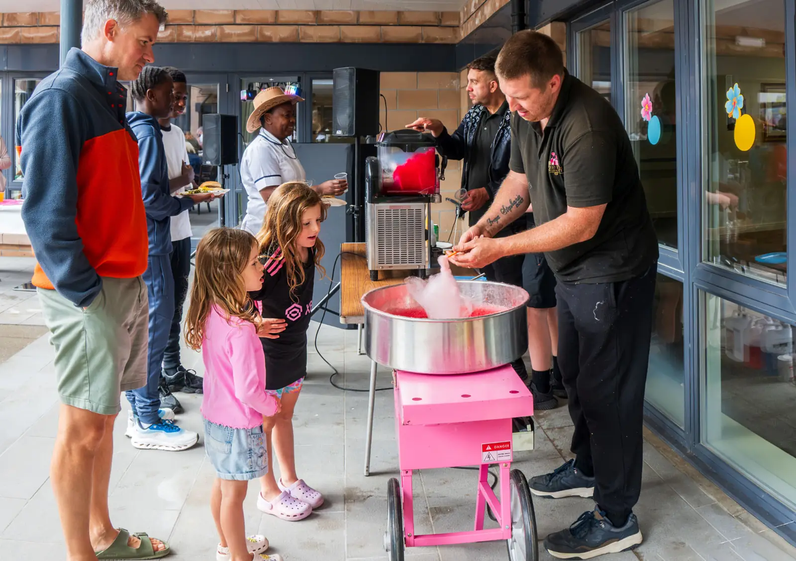 Children watching candy floss being spun at the Mearns House Care Home summer fete in Newton Mearns