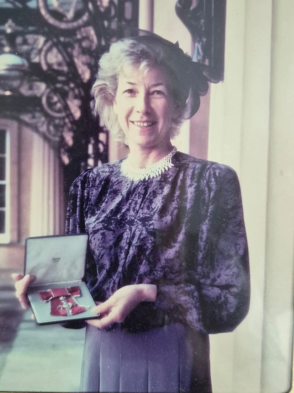 Moira Ord holding her MBE, awarded for services to netball in 1988