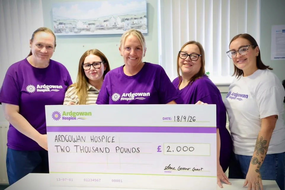 Kincaid House care home team in Ardgowan Hospice t-shirts presenting a £2,000 cheque to Ardgowan Hospice in Greenock