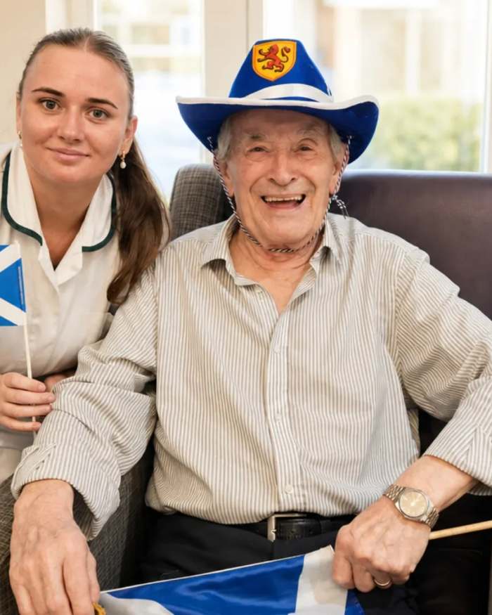 A resident holding a Saltire during a Scottish themed celebration at St Modans Care Home in Fraserburgh