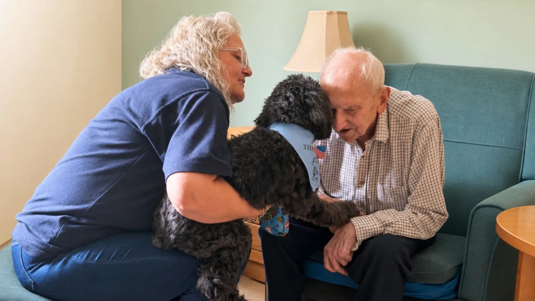 A resident stroking a visiting dog with a colleague at St Modans Care Home in Fraserburgh